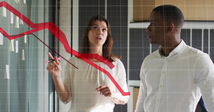 Image of red graphs moving over diverse man and woman discussing over memo notes at office