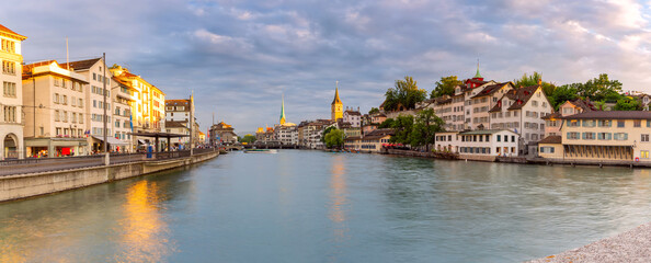 Panorama of Fraumunster church and Munsterbrucke bridge over river Limmat at sunset in Zurich, Switzerland