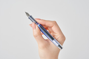 万年筆を持つ女性の手と白い背景