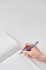 万年筆を持つ女性の手と原稿用紙