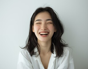 A beautiful Asia woman in her 20s is laughing with her teeth showing. - obrazy, fototapety, plakaty