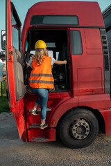 Back view, woman truck driver entering the vehicle 
