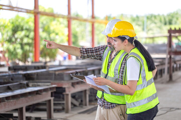 Engineer and female foreman worker team checking project at precast factory site, Engineer and...