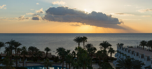 Obraz premium Sunrise on the sea coast. The movement of the sun and clouds across the sky. Park recreation areas of Egypt. Garden and landscape design.