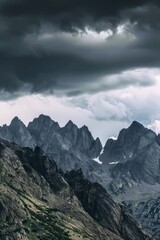 Obraz premium A rugged mountain range obscured by dark clouds, with jagged peaks disappearing into the gloom of an approaching storm, Generative AI