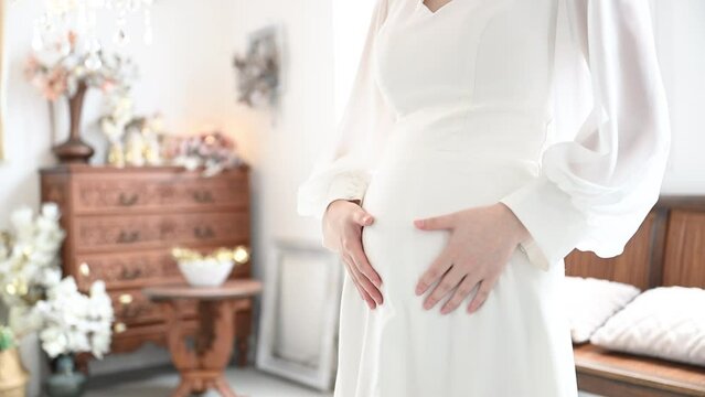Image of maternity photo for wedding ceremony Faceless hand and close-up of belly Video of preliminaries and image of a happy, pregnant woman,slow