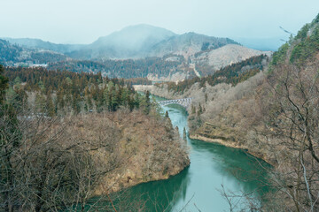 Panoramic View of Japan local train with Tadami river and bridge. Tadami Railway Line in The Valley at Mishima Machi, Aizu, Fukushima Prefecture, Japan. Landmark and iconic spot for tourist attraction
