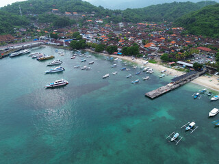 Aerial view of Padang Bai port town in Bali. Ferry and Yacht docked at the port.