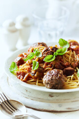 Spaghetti Pasta with Meatballs and fresh Basil o bright background. Close up.	