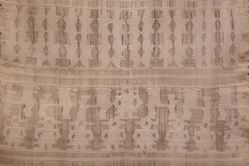A tan and brown woven fabric with a pattern of lines and dots