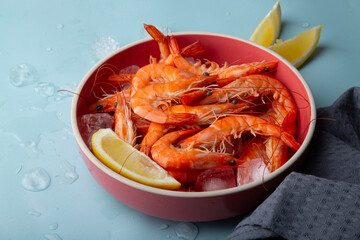 Freshly served seafood, boiled prawns in a coral-colored bowl, dining concepts or recipe illustrations.