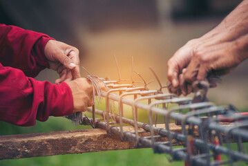 Construction Men hands bending cutting steel wire fences bar reinforcement of concrete work. Worker...