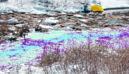 Multi- colored river with gold rock in snow.