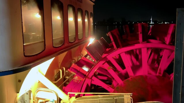 Paddle wheel of tourist steamboat on Mississippi river near New Orleans, Louisiana at night time