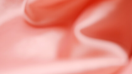 Blurred pink satin fabric texture. Beautiful bright pink fabric background. Abstract shape and curve of fabric texture. Pink satin in the concept of wavy, beauty, and fashion. Blurry background.