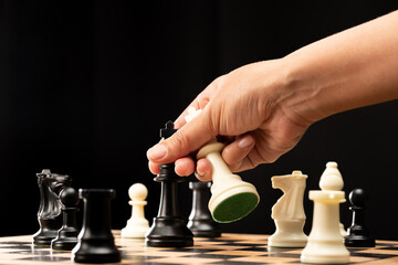The hands of man on the competition and the strategic planning guidelines on the checkmate board. Succeed