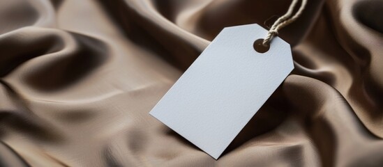 White clothing tag, label blank mockup template , On a premium cotton brown silk fabric textile background.high resolution