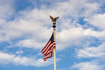 US American flag waving in the wind with beautiful blue sky in background. American flag on blue...