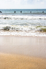 波打ち際のアップと遠くに見える波間のサーファー達