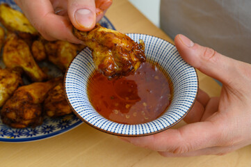 Pieczone skrzydełka z kurczaka jedzone z pikantnym sosem chilli 