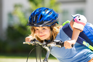 Little kid boy ride a bicycle in the park. Kid cycling on bicycle. Happy smiling child in helmet riding a bike. Boy start to ride a bicycle. Sporty kid bike riding on bikeway. Kids bicycle.