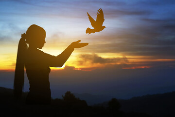 Silhouette pigeon fly out from women hand
