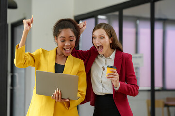 Two happy African American businesswomen using laptops with smiling female consultant. Expressing joy, surprise. Working together. Online business concept in finance, marketing.