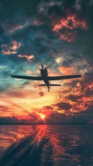 Naklejka premium A small plane is flying over a body of water at sunset. The sky is filled with clouds and the sun is setting, creating a beautiful and serene atmosphere