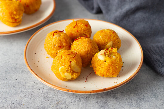 Indian Sweets laddoo or Laddu made of gram flour on a grey background. 