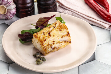 Roasted cod fish steak with salad