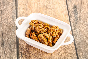 Cracked unshelled walnut in the bowl