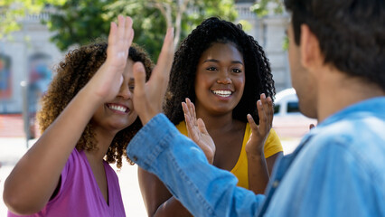Group of happy international young adults giving high five