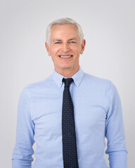 Portrait of a grey haired businessman standing against isolated background