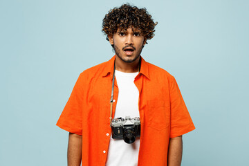 Traveler frowning sad mad Indian man wear orange casual clothes look camera isolated on plain blue...