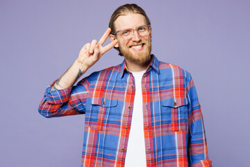 Young smiling cheerful happy man he wear blue shirt casual clothes showing cover eye with victory sign look camera isolated on plain pastel light purple background studio portrait. Lifestyle concept.