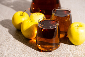 Apple juice in a glass and jug on a white background