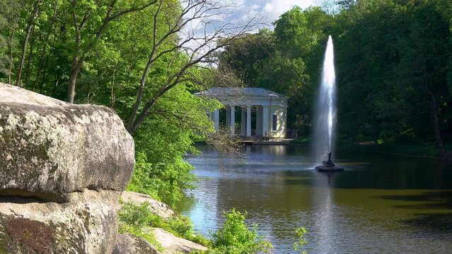 Snake fountain on the lake and white gazebo in Sofiyivka park. Famous National Dendrological Park Uman Ukraine.