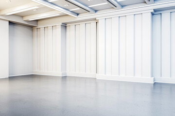 An empty gallery space with white walls and a gray floor, designed for contemporary art...