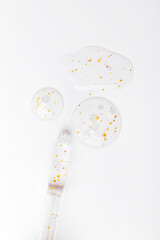 serum pipette serum gel essence texture with gold on white background