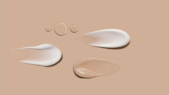 pattern brush strokes of creamy texture of cosmetic samples on a pastel beige background