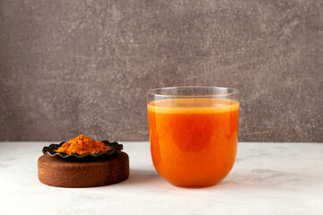 Glass of turmeric energy drink. Fruits vegetable smoothie with indian spicy spices. Ayurvedic...