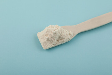 Ceramic spatula with Guar gum powder, close-up. Food additive E412 widely used in bakery, confectionery products. Softness, Fat Replacer, Dough Improver, Improve Moisture, Structure, Texture