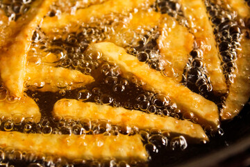 French fries in a frying pan with hot oil