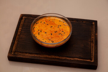 Sea buckthorn smoothie in glass bowl on wooden board. Detox drink. Healthy breakfast
