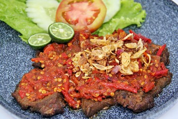 Empal Penyet consists of deep-seated beef cooked with kitchen spices such as bay leaves, galangal, lime leaves, tamarind, shallots, garlic, and many more.