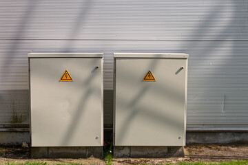 Electricity control box with sign. Two transformer box at the metal facade building. 