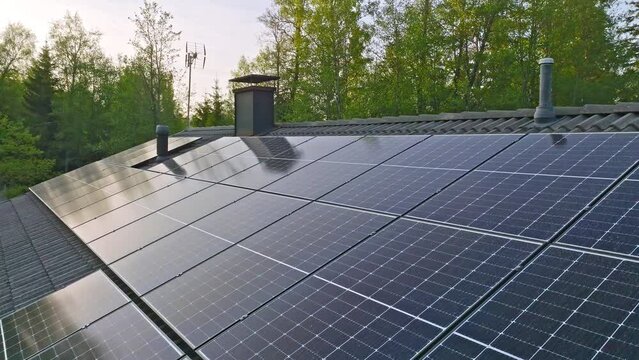 Reflecting sunlight absorbers on a modern house roof, summer sunset - Drone shot