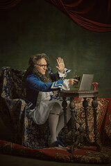 King, man in classical baroque-style attire drink wine while holding meeting online against vintage...