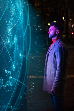 Businessman standing in front of big blockchain data at night