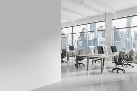 Office workplace interior with pc desktop on tables in row, window. Mockup wall
